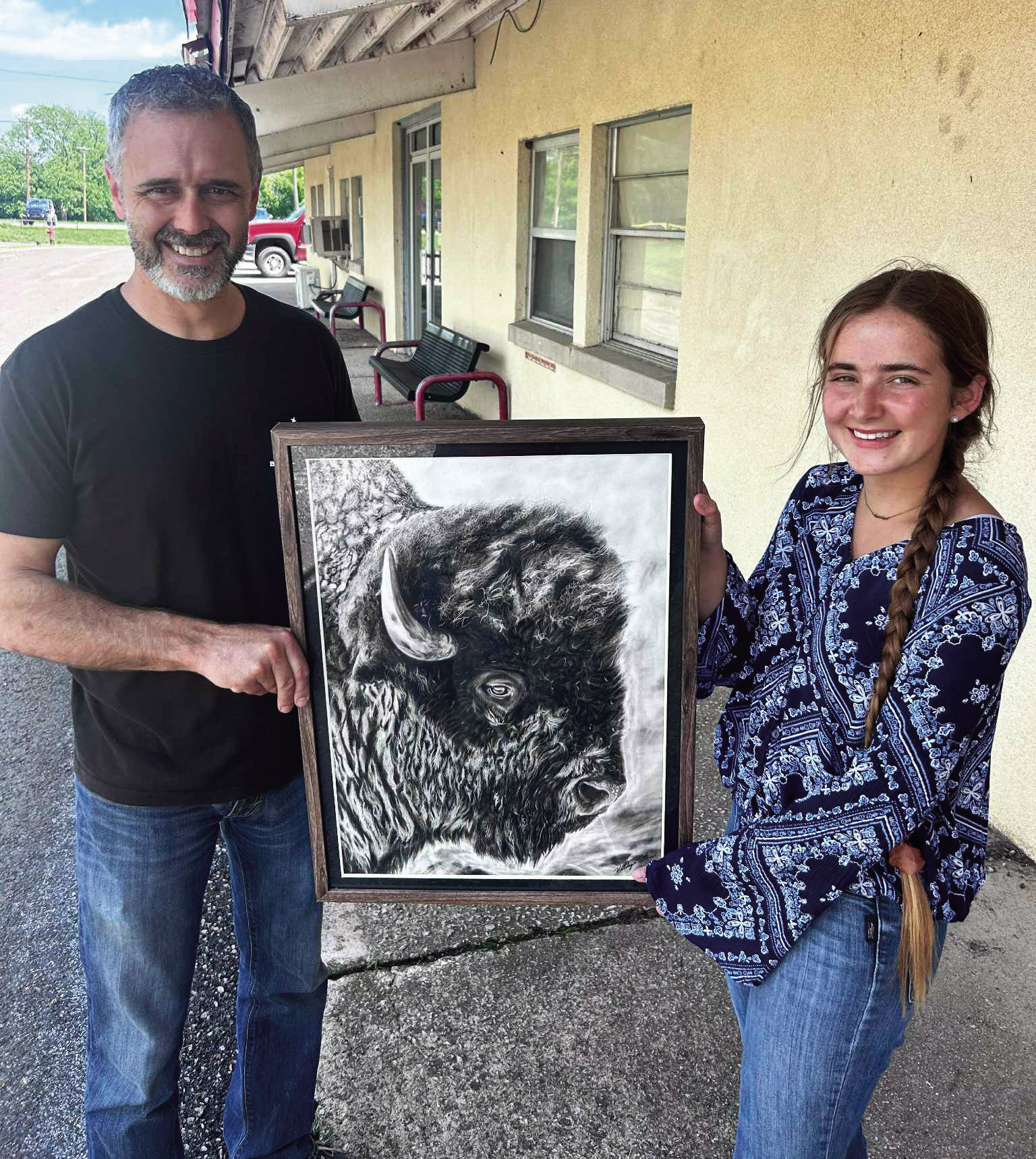 Katelyn Estes and her art teacher Shea Meyer display her charcoal piece “Spirit of the Plains.”
