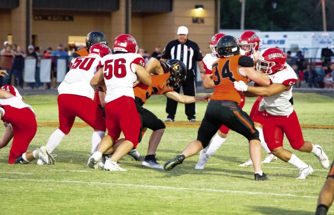 Lindsay's Priest Williams battles two of Purcell's offensive linemen to get to the Purcell quarterback. Lindsay won the battle against Purcell 12-7. News Star photo by Kristy Schrader