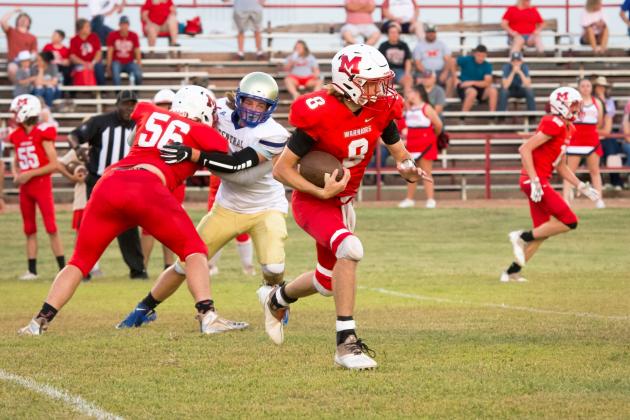 #8 Bo Green looks for an opening as #56 Kolby Wyatt blocks a Central Marlow defensive back. Photo by Kristy Schrader