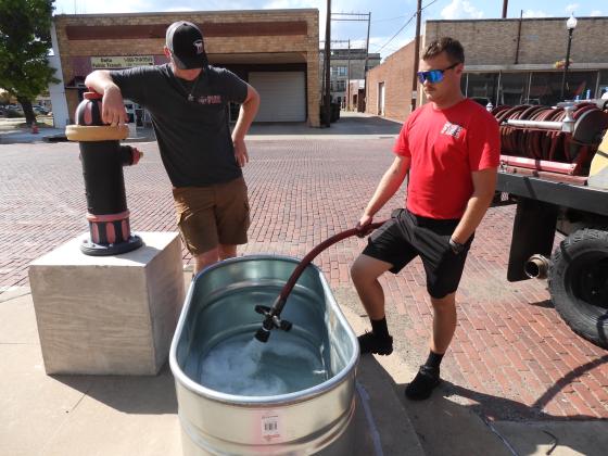 Pauls Valley fire fighters helped set up "refill" stations along Paul Ave. prior to Monday's parade. News Star photo by Chris Mackey.