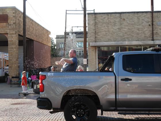 Pauls Valley Police Officer Sterling Redden tosses water balloons at the crowd. News Star photo by Chris Mackey
