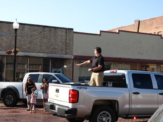 Pauls Valley Officer Grant English tosses water balloons during the Water Fight Parade. News Star photo by Chris Mackey