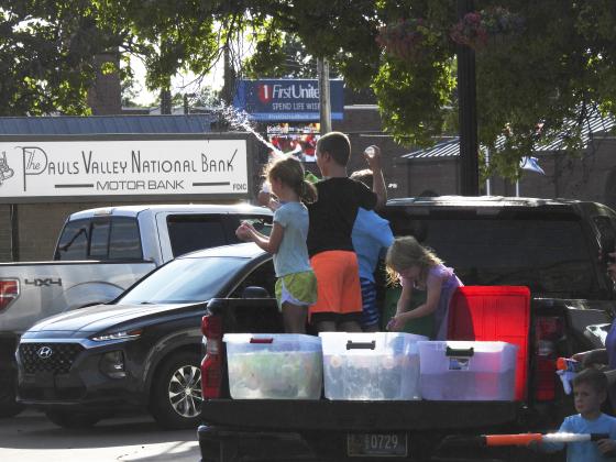 Kids take aim at parade vehicles from the back of a parked pickup stocked with water balloons. News Star Photo by Chris Mackey.