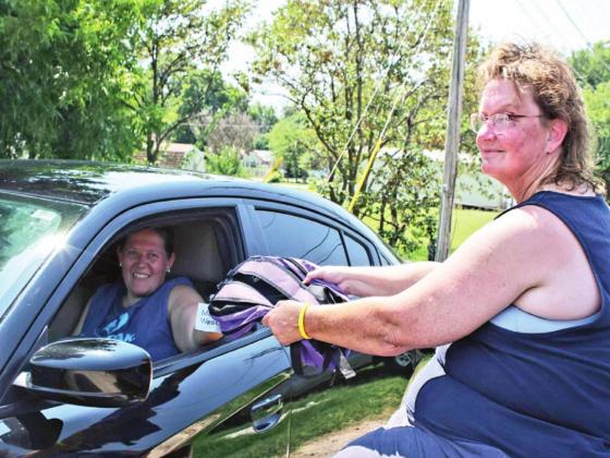Bev Barker hands out a free backpack at the Linday Senior Center over the weekend. Volunteers distributed 500 backpacks to area students in need. Photo by Ashley Gallagher