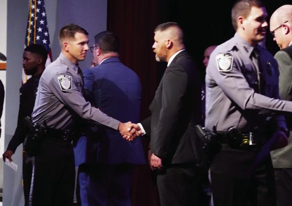 Sen. Jonathan Wingard, R-Ada, (center) shakes hands with Teagon Moler, of the Elk City Police Department, at Friday’s CLEET graduation ceremony at Ada High School.