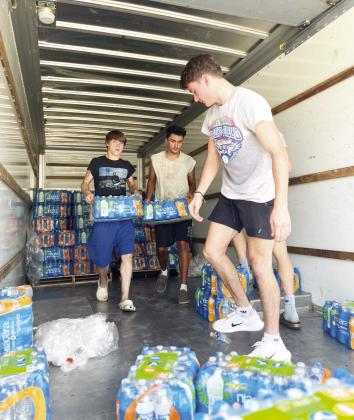 Maysville students volunteered Monday to help distribute donated drinking water to residents.