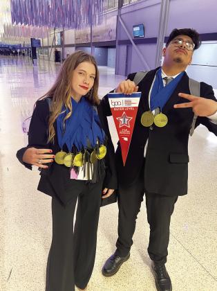 Adult students in Mid-America Technology Center's Multimedia Production program, Kendall Edelen and Neftali Baquera, display MATC’s Business Professionals of America Silver Chapter Award and some of the medals brought home by MATC students.