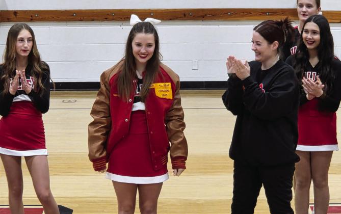 Surrounded by the Panther cheer squad, PVHS Head Cheer Coach Bailey Ratchford, front right, presents Gracy Manning, front left, with her All-Region Cheer Team jacket during the halftime of Tuesday’s boys basketball game. News Star photo by Jennifer Lindsey