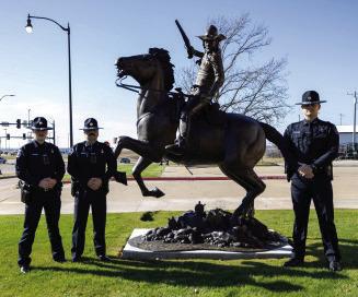 Chickasaw Lighthorse Officers Wes Harden, Jerald McDonald and Dalton Reed stand with the bronze, larger-than-life Chickasaw Lighthorse monument created by artist James Blackburn. Courtesy Photo