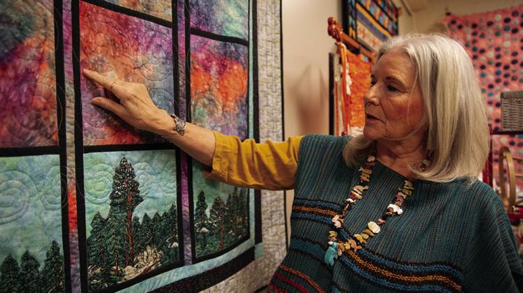 Mary Wilds examines “Storm Clouds over the Arbuckle,” one of many quilts and textiles the Chickasaw artist plans to show at the Southeastern Art Show and Market (SEASAM) scheduled Oct. 4-5 in Tishomingo, Oklahoma. Photo courtesy of Chickasaw Nation. Courtesy photo