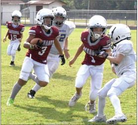 Wynnewood #3 JaKobi Whitaker and #1 Jaxsyn Knighten, try to avoid the Ringling Blue Devil linebacker in the first game of the Wynnewood’s youth tackle program after a 10-year absence. News Star photo by Don Coffey