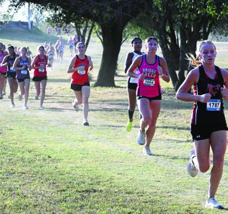 Lindsay‘s Cheyenne Lamb chases down a Tishomingo runner, Kynna Brannan of Bridge Creek and Pauls Valley’s Hannah White in the 3200-meter XC run at Waurika Tuesday. News Star photo by Don Coffey