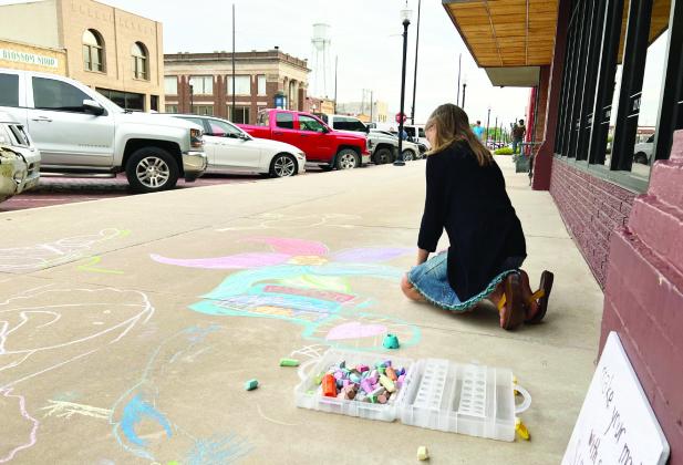A young artist chalks the sidewalks in downtown Pauls Valley during a Fifth Friday Art Walk last summer.