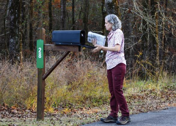 Hochatown Trustee Dian Jordan retrieves her mail on Dec. 12, 2025. (Riley Gamble/Oklahoma Watch)
