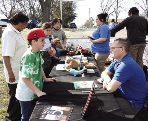 Author Wiley Barnes (seated right) visited with young readers and signed books during the community kick-off event for Stratford's Trails and Tales StoryWalk Saturday. Barnes' children's book 'Funny Fani'' is the featured title for Trails and Tales this month. The StoryWalk is located at Stratford's Town Park, Patterson and 7th Street. News Star photo by Chris Mackey