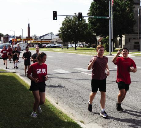 OU's Naval ROTC members carrying the game ball through Pauls Valley Wednesday. News Star photo by Chris Mackey