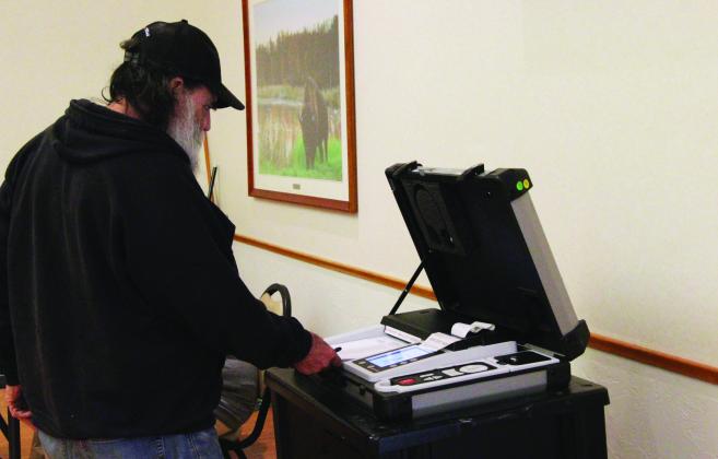 Gary Corn, 74, inserts his ballot into the voting machine during a special election on the adult use of recreational marijuana in Oklahoma, March 7, 2023, at a Del City Community Center polling station. Lionel Ramos/ Oklahoma Watch