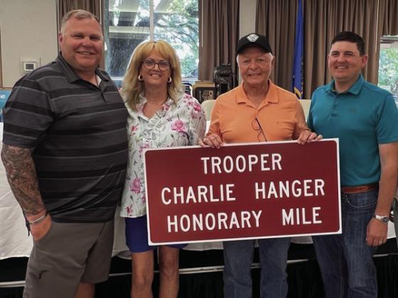 Reps. Ty Burns and John Pfeiffer recently presented Charlie and Beverly Hanger with a replica of a sign that will be displayed at Mile Marker 202 in Noble County. Courtesy photo