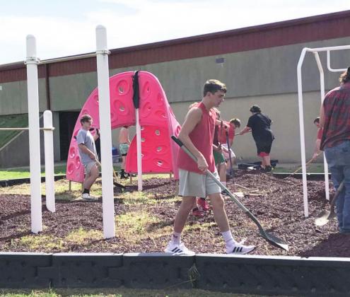 Maysville football players help spread mulch