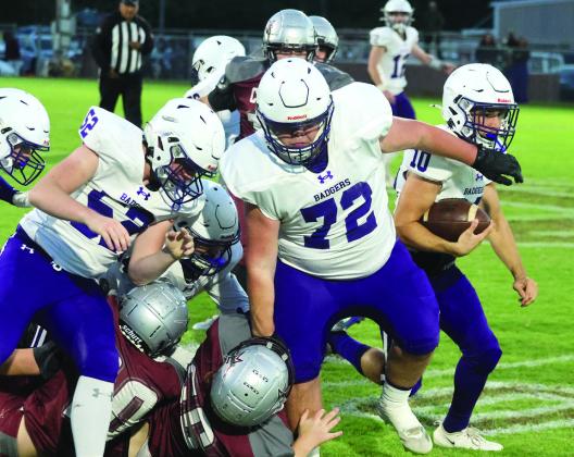 Elmore City-Pernell's Colt Matthews (#10) runs behind the block of Eli McConnell (#72) and Devin Stanley (#52) during Friday's game at Velma-Alma. Photo by Mike Arie
