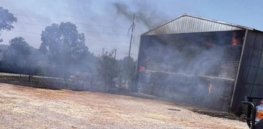 As temperatures continued to soar over 100 degrees this week, Maysville and Rush Creek Volunteer Fire Departments stood watch over a hay barn that caught fire Tuesday afternoon about a quarter mile south of Maysville on Hwy 74. The amount of hay inside the barn prevented fire crews from extinguishing the fire, which had to be treated as a controlled burn.