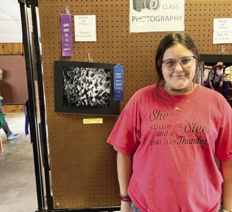 Ellexys Madison of Maysville poses with her photo entry at the Garvin County Free Fair last week. Madison won first place and Best of Show in the youth division.