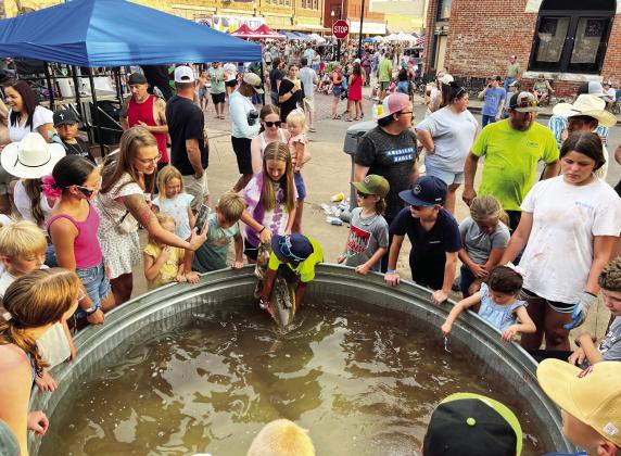 A tank stocked with large catfish was a big draw for young spectators at the 2025 Okie Noodling Tournament. News Star photo by Suzanne Mackey