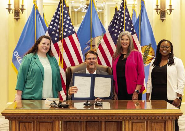 (L-R) Health Minds Policy Initiative Policy Director Brittany Hayes, Rep. Cynthia Roe, and Behavioral Health Workforce Project Director Tequia Sier join Gov. Kevin Stitt (seated) for the ceremonial signing of House Bill 3330 on Tuesday, July 9 at the Oklahoma State Capitol. Courtesy photo