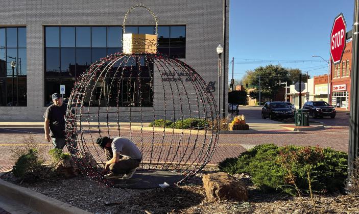 Pauls Valley city employees worked Wednesday to put the finishing touches on one of two 10-foot-by-10-foot wrought iron Christmas ornaments decorating the downtown area this holiday season. News Star photo by Suzanne Mackey