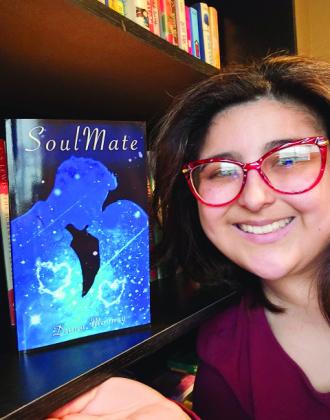 Local indie author Diana Mooney poses with her first published novel, “SoulMate.” Courtesy photo