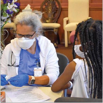 A nurse prepares to wipe a teenager's arm with an alcohol pad at a COVID-19 vaccination drive at Voice of Praise Baptist Church in Oklahoma City on Saturday, Sept. 25, 2021. (Rebecca Najera/Oklahoma Watch)