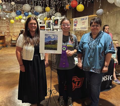 Left to right: FCS and 4-H Educator Julie Selman, Paetyn Woodring, and Extension Program Assistant Traci Mullendore at July’s Fifth Friday Art Walk, where Woodring was the big winner at the 2026 Garvin County News Star and Garvin County 4-H photo contest, earning the “Best of Show” title for her work, “The Red Barn.” Photos from all the club members were on display at the Pauls Valley Art Council’s Fifth Friday Art Walk July 31. Courtesy photo