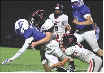 Panther defense makes a stop against the Dickson Comets during last Friday‘s season opener at Dickson. Photo by Mike Arie