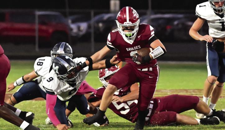 Wynnewood’s Peyton Henderson takes out two Minco Bulldogs for Aydrian Knighten to run the ball down the field. Wynnewood remains undefeated after a 28-20 win over Minco. News Star photo by Don Coffey