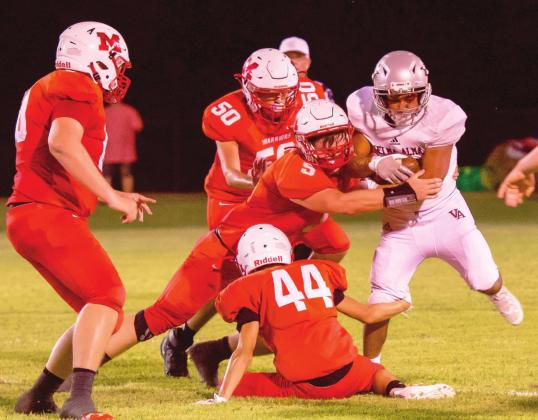 #5 Nigel Reid, #44 Holden Tyler and #50 Patricio Recendiz tackle the Comet runner during last week’s game. Photo by Kristy Schrader