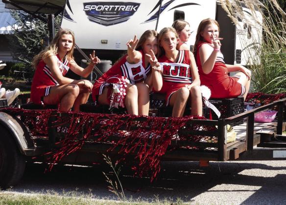Maysville junior high cheerleaders strike a pose as they wait for the homecoming parade to begin last Friday.