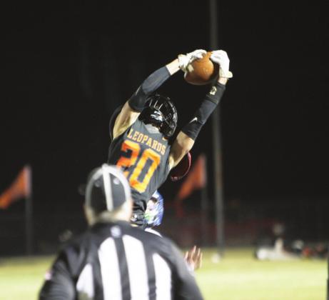 Lindsay High School's #20 Andon Register reaches high to snag this pass from Leopard quarterback Broty Ramming. Photo courtesy of Sheryl Kochert