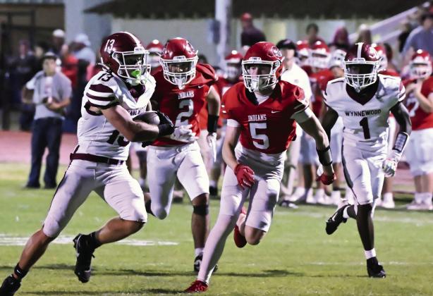 Wynnewood’s #13 Briar Davenport and #1 Marques Williams run away from the Comanche defense in Wynnewood’s season opening win, 31-6. News Star photo by Don Coffey