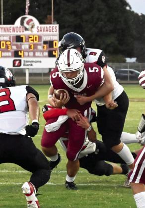 Wynnewood‘s Jake Everett drags the Indians for extra yards in the Savages’ win last week 17-14. News Star photo by Don Coffey
