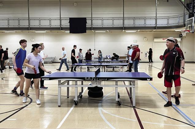 Menglin Hi (left), of Norman, serves the ball during a practice match with Dennis Rhodes (right), of Oklahoma City, and Imre Simonji, of Norman, at the Valley Paddle Battle Saturday.