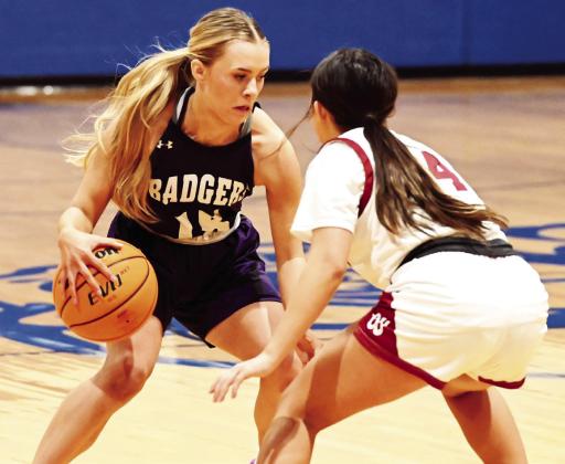 Elmore City-Pernell’s Valerie Riddle brings the ball down court against Wynnewood’s Jasmine Willey in the first round of the Bulldog Bash at Healdton. The Lady Badgers pulled a two point win 57-- 55 to move on to the second round of the winners bracket. News Star photo by Don Coffey