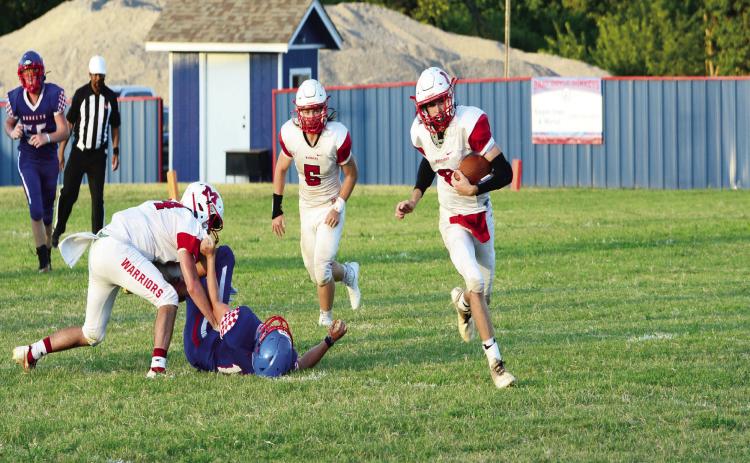 Warrior Bo Green scrambles around the end of the Bray-Doyle line in last week’s game. News Star photo by Denny Park