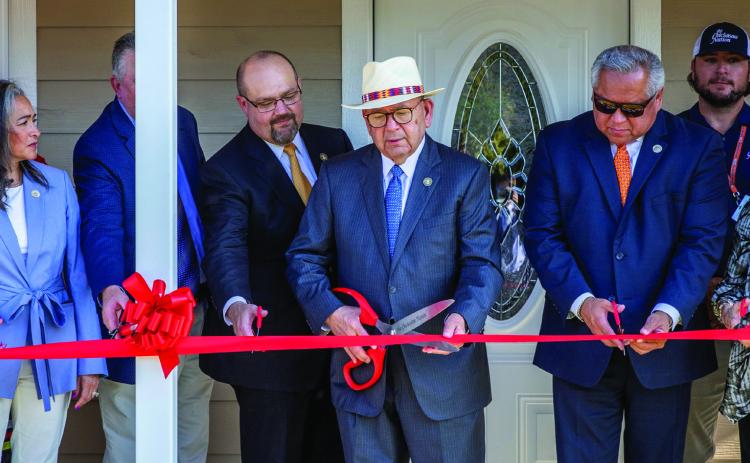 Chickasaw Nation Governor Bill Anoatubby, center, is joined by Chickasaw Nation Lt. Governor Chris Anoatubby, Chickasaw veterans and tribal, federal and local dignitaries in ribbon cutting ceremonies to dedicate the Tashka Inchokka' neighborhood, Aug. 14 in Ada. The housing community is designed for Chickasaw veterans.