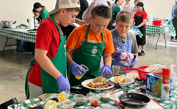 Maysville 4-H members (l-r) Lawson Thompson, Case Baker and Jaxon Thompson put the finishing touches on their competition plate during the Garvin County 4-H Food Showdown contest April 8. News Star photo by Suzanne Mackey