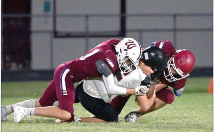 Wynnewood’s Phoenix Sparks and a fellow teammate tackle the Tishomingo ball carrier in Tuesday night’s victory over Tish, 14-6. News Star photo by Don Coffey