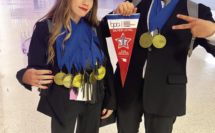 Adult students in Mid-America Technology Center's Multimedia Production program, Kendall Edelen and Neftali Baquera, display MATC’s Business Professionals of America Silver Chapter Award and some of the medals brought home by MATC students.