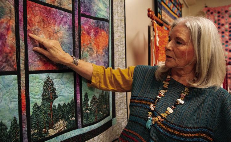 Mary Wilds examines “Storm Clouds over the Arbuckle,” one of many quilts and textiles the Chickasaw artist plans to show at the Southeastern Art Show and Market (SEASAM) scheduled Oct. 4-5 in Tishomingo, Oklahoma. Photo courtesy of Chickasaw Nation. Courtesy photo