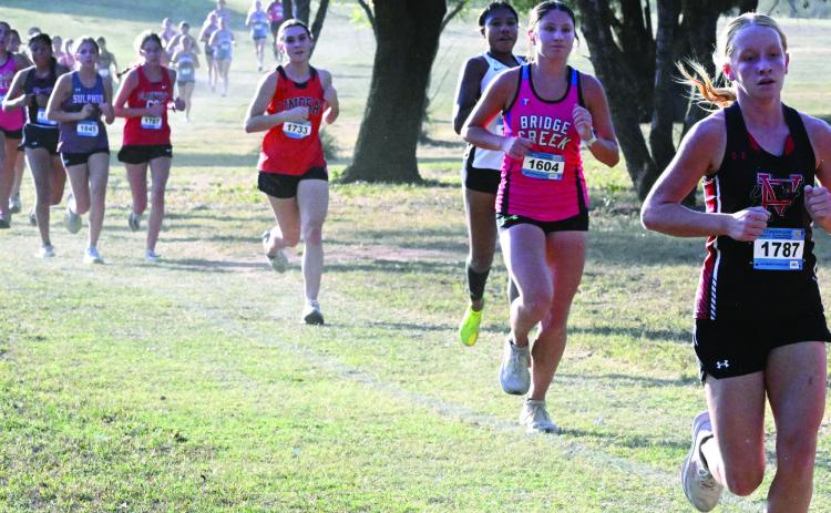 Lindsay‘s Cheyenne Lamb chases down a Tishomingo runner, Kynna Brannan of Bridge Creek and Pauls Valley’s Hannah White in the 3200-meter XC run at Waurika Tuesday. News Star photo by Don Coffey