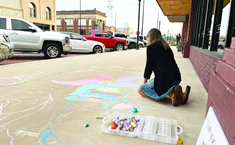 A young artist chalks the sidewalks in downtown Pauls Valley during a Fifth Friday Art Walk last summer.