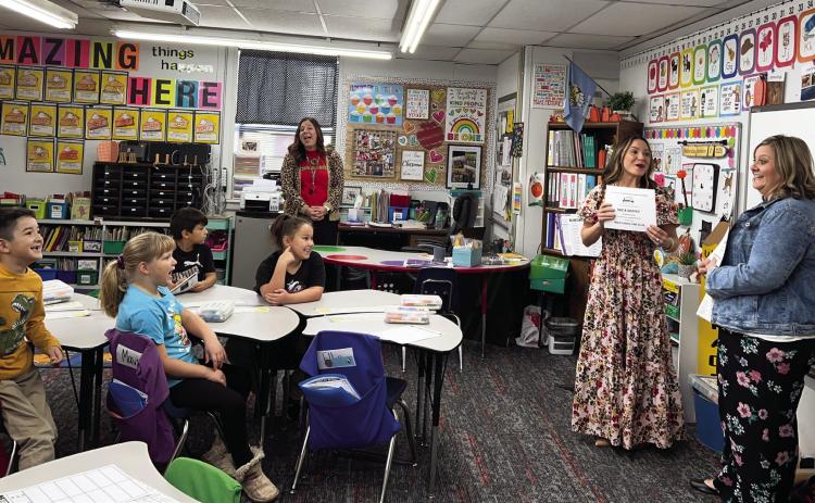 PVFAE’s Camille Milligan shares with Whitebead teacher Erica Shippey (far right) and her first-grade students that all three of the grant applications Shippey submitted were funded. News Star photo by Suzanne Mackey